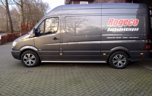 Grijze bedrijfsbus van Rogeco Dakbedekkingen met logo op de zijkant