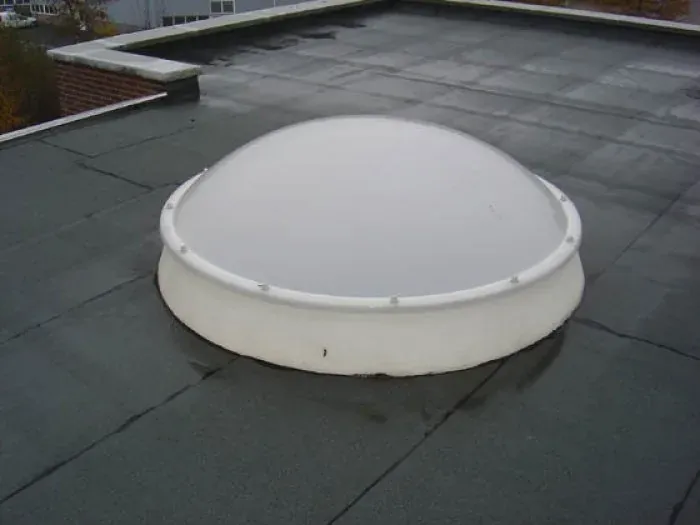 Lichtkoepel op een plat dak met zwarte bitumineuze dakbedekking